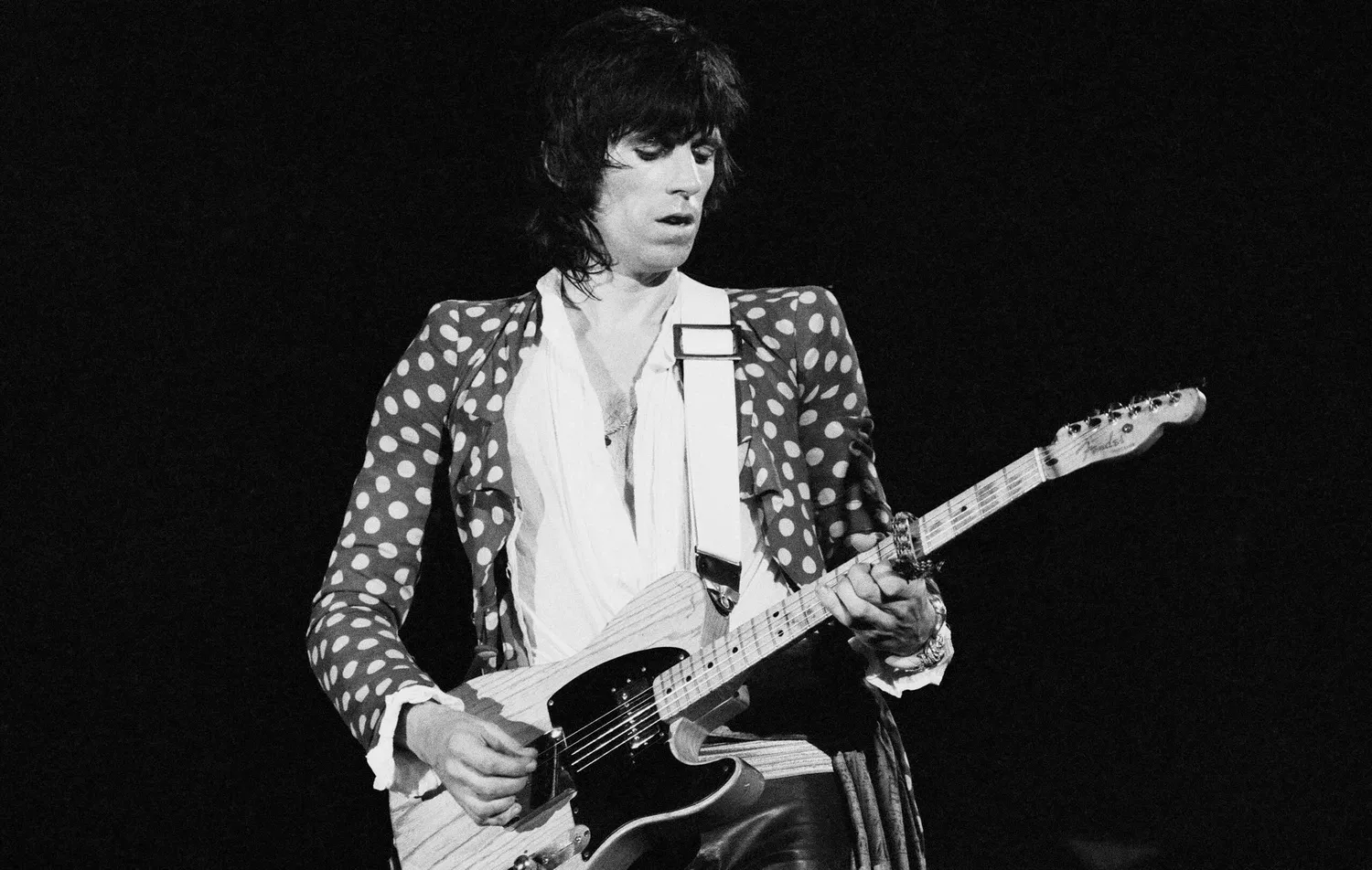 Keith Richards playing the guitar on stage