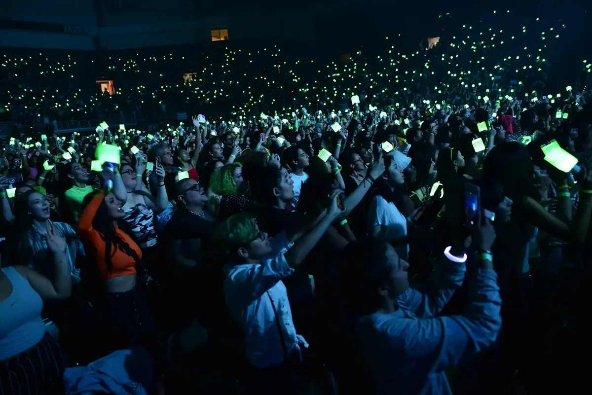Fans holding light sticks at a K-pop concert