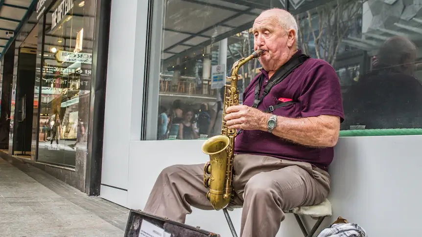 A talented busker playing Christmas tunes to an enchanted Australian crowd