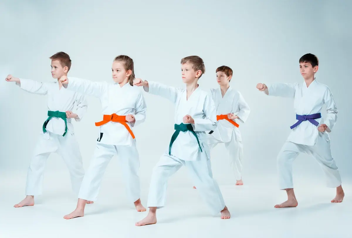 The group of boys and girl fighting at aikido training in martial arts school