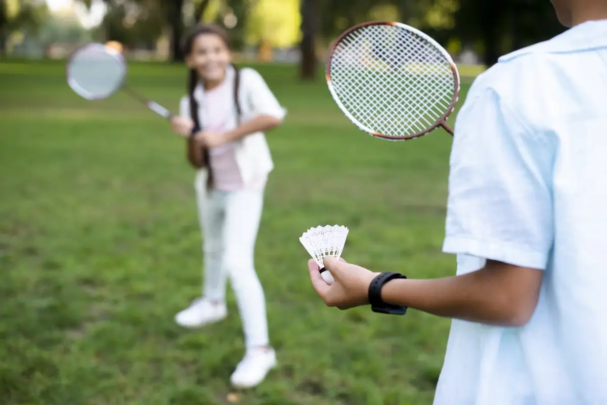 Kids playing badminton on beautiful summer day