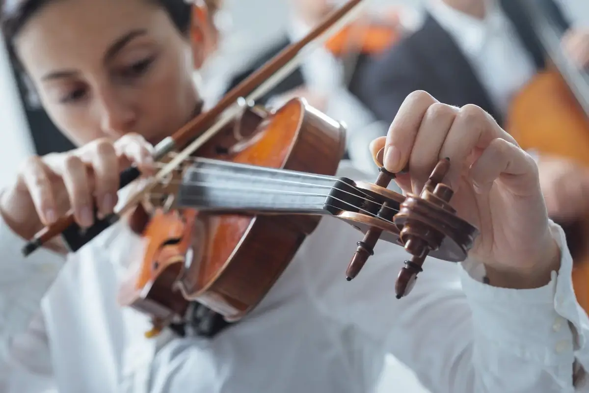 A violinist tuning their instrument