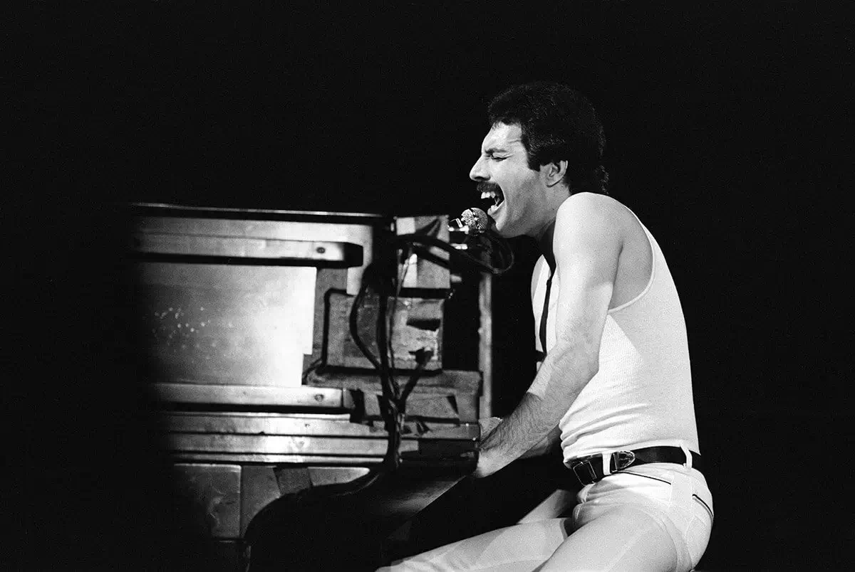  Freddie Mercury seated at his piano on stage