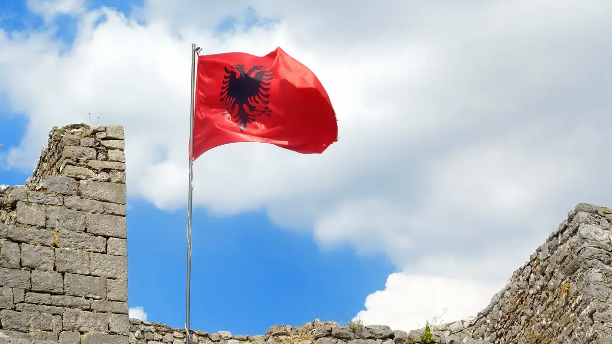 The Albanian flag waving proudly against a clear sky